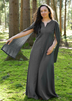 Robe Elira à manches longues en coton gris, portée de face en forêt avec coupe longue fluide pour reconstitution ou LARP