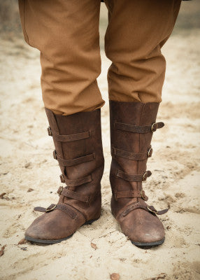 Bottes médiévales en cuir suédé présentées en marron et noir, cinq boucles en laiton, vues latérales sur fond blanc