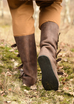 Vue arrière des bottes médiévales marron en cuir suédé portées, semelle caoutchouc visible, usage adapté aux sols modernes