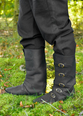 Bottes médiévales noires en cuir suédé portées de face, cinq boucles en laiton réparties de la cheville au mollet