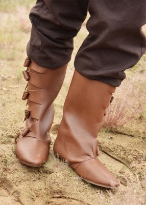 Bottes vikings marron portées aux pieds, avec tiges hautes et boutons latéraux, pour reconstitution, GN ou LARP