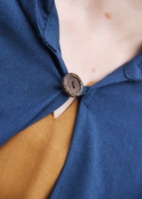 Cape Paul pour enfant en coton bleu, détail de la fermeture avec bouton en bois et boucle pour reconstitution, GN ou LARP enfant