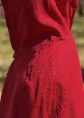 Cape Paul pour enfant en coton rouge, détail du tissu et de la couture latérale visible pour reconstitution, GN ou LARP enfant