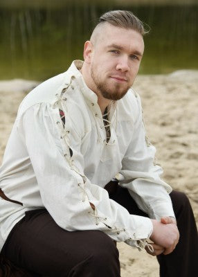 Chemise Corvin naturelle portée assise, avec manches lacées et col montant lacé