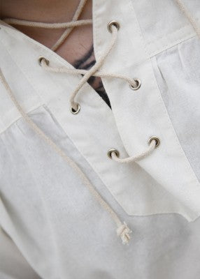 Détail de l’encolure lacée de la chemise Corvin naturelle, avec œillets métalliques