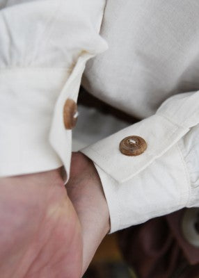 Détail du poignet de la chemise Götz naturelle, avec bouton en bois et manche resserrée