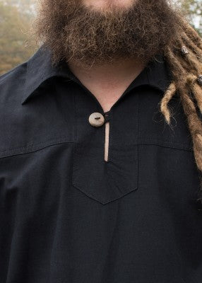 Détail du col simple et du bouton en bois de la chemise Götz noire en coton