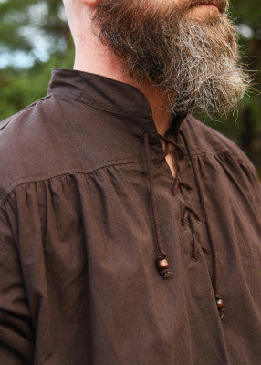 Détail de l’encolure lacée de la chemise Ludwig brune, avec col montant, cordons et perles en bois