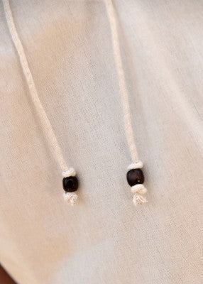 Détail des cordons à perles en bois de la chemise manches courtes naturelle