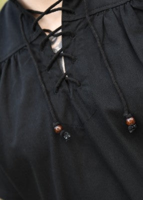 Détail du col lacé de la chemise manches courtes noire, avec perles en bois et fronces sur l’empiècement