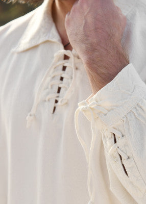Détail de l’encolure lacée et du poignet resserré de la chemise médiévale en coton naturel