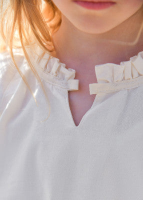 Chemisier Birga pour enfant en coton blanc, détail de l’encolure froncée avec finition volantée pour reconstitution, GN ou LARP enfant