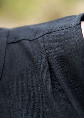 Chemisier Levke en coton noir, détail de la couture d’épaule et de la texture du tissu pour tenue de reconstitution ou GN