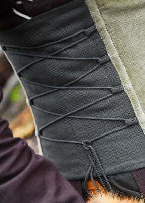 Gros plan du laçage latéral du corsage Anik vert, avec contraste noir et vert pour reconstitution, GN ou LARP