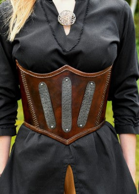 Corsage sous-poitrine en cuir renforcé brun, porté de face, avec plaques métalliques rivetées