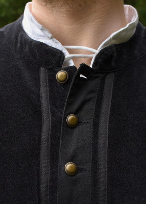 Détail du devant du doublet Victor noir, avec boutons métalliques décoratifs et bandes appliquées