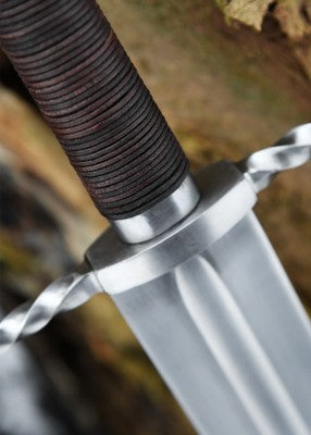 Épée bâtarde à pommeau en coquille cannelée – garde torsadée et base de lame – gros plan sur poignée brune et ricasso scène