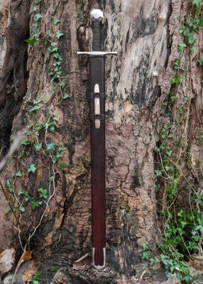 Épée de croisé à pommeau octogonal – fourreau cuir brun avec insert bois – vue verticale contre tronc d’arbre et lierre vert