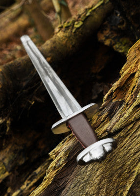 Épée viking Wheeler VI SK-C posée sur un tronc vue en diagonale pour montrer la lame et le pommeau trilobé, escrime en scène