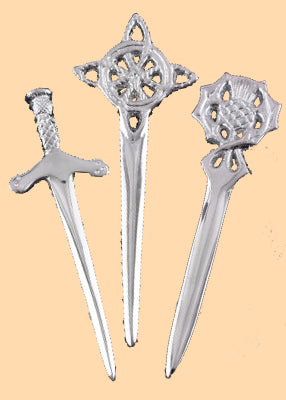 Épingle de kilt en laiton chromé présentée avec les 3 motifs : épée, chardon et nœud celtique