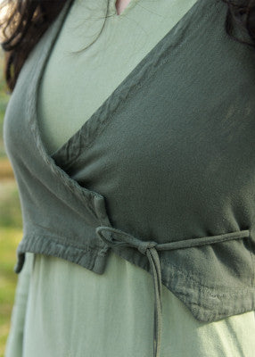 Détail de la fermeture croisée du gilet à capuche Nalen vert foncé, avec lien en tissu