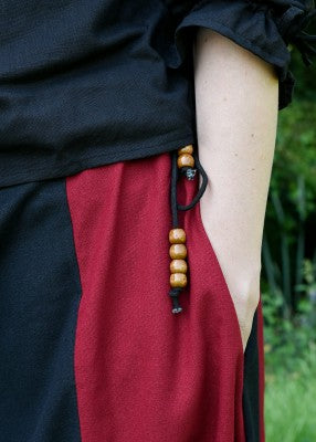 Détail de la poche intérieure de la jupe bicolore noir et rouge, avec accessoire suspendu sur le côté