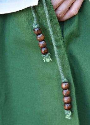 Détail du cordon perlé de la jupe verte en coton, près de la poche intérieure