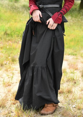 Jupon médiéval noir en coton, porté sous une robe relevée avec volant froncé visible en bas