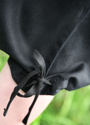 Pantalon court Jonte pour enfant en coton noir, détail du bas ajustable avec liens pour reconstitution, GN ou LARP enfant