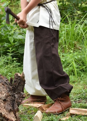 Pantalon large Thore pour enfant en coton brun et naturel, porté de profil avec bottes pour reconstitution, GN ou LARP enfant
