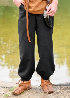 Pantalon large Thore pour enfant en coton noir, porté de face avec bas resserrés visibles pour reconstitution, GN ou LARP enfant
