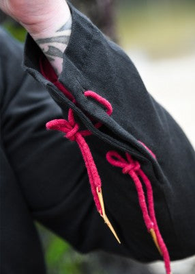 Détail du poignet du pourpoint Bernhard noir, avec laçage rouge bordeaux et doublure contrastée