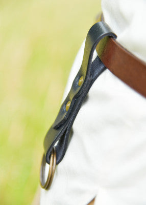 Vue de profil du relève-jupe noir en cuir, porté à la ceinture avec double anneau
