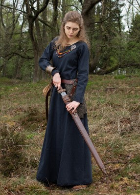 Robe Afra bleu nuit portée avec épée et ceinture, montrant la coupe ample et la jupe évasée