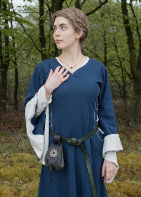 Portrait de la robe bliaut Amal bleu et blanc portée avec ceinture et aumônière en extérieur