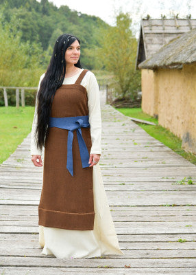 Robe tablier viking Annik brune portée sur robe claire avec ceinture bleue pour reconstitution historique, GN et LARP