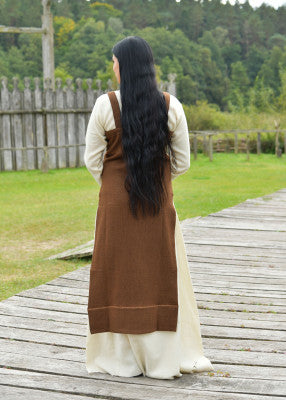Vue arrière de la robe tablier viking Annik brune portée sur robe claire pour reconstitution historique, GN et LARP