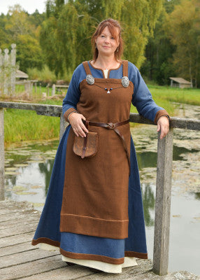Robe tablier viking Annik brune portée sur robe bleue avec broches décoratives pour reconstitution historique, GN et LARP