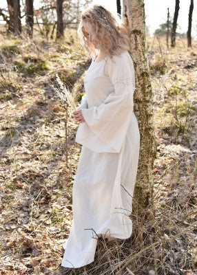 Vue de profil de la robe Burglinde blanche à manches trompette en extérieur