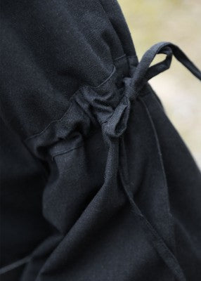 Détail du laçage au haut du bras sur la robe Burglinde noire à manches trompette