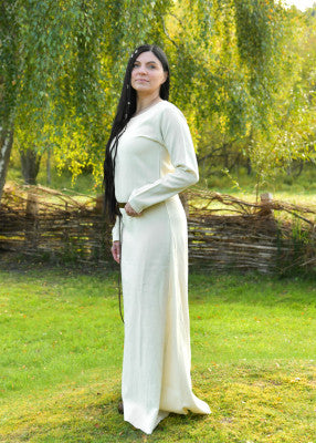 Vue de profil de la robe viking Celeste blanche en laine, portée avec ceinture en extérieur