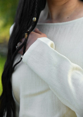 Détail de la manche longue et du tissu blanc de la robe viking Celeste en laine