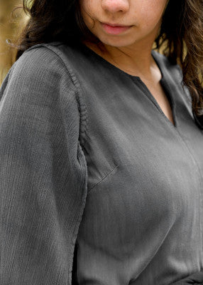 Robe Elira en coton gris, gros plan sur l’encolure fendue et la manche longue ouverte pour tenue de GN, LARP ou reconstitution