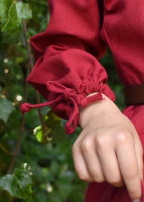 Robe Ana pour enfant en coton rouge, détail de la manche resserrée par lien pour reconstitution, GN ou LARP enfant