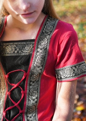 Robe Eleanor pour enfant en coton rouge-noir, détail de la bordure dorée décorative et du laçage avant pour reconstitution, GN ou LARP enfant