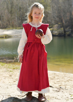 Robe Lilou pour enfant en coton rouge, portée de face en extérieur sur robe simple pour reconstitution, GN ou LARP enfant