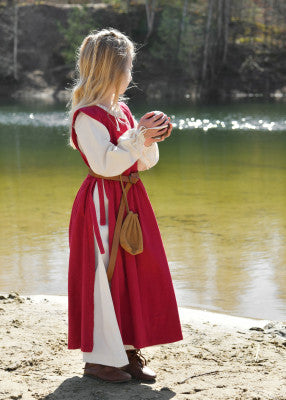 Robe Lilou pour enfant en coton rouge, portée de profil en extérieur avec bourse à la ceinture pour reconstitution, GN ou LARP enfant
