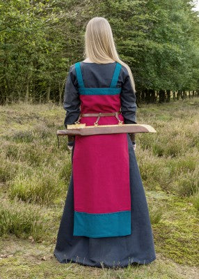 Robe tablier viking Hilja rouge et bleu pétrole portée avec ceinture, montrant la broderie poitrine