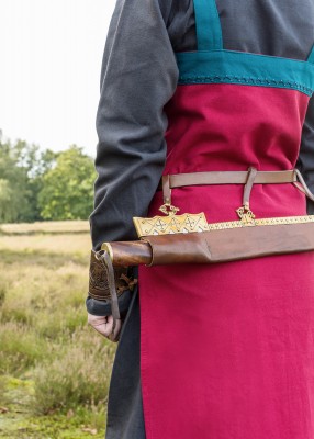 Robe tablier viking Hilja rouge et bleu pétrole portée en extérieur, avec coupe ample et finitions contrastées