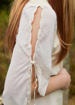 Détail de manche fendue avec liens sur robe médiévale Ingrid écru, coton léger, finition soignée et fluide